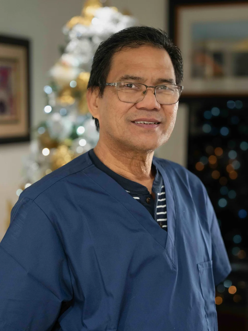 Healthcare professional in navy scrubs smiling warmly in residential care home