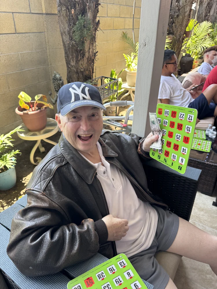 Resident enjoying outdoor bingo game activity on facility patio
