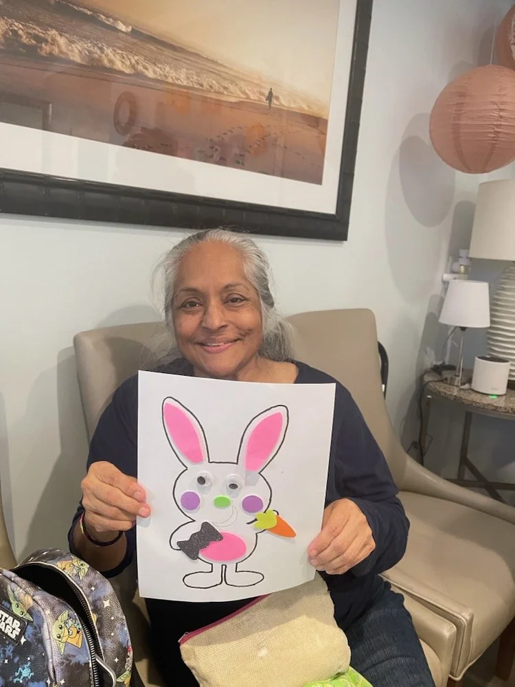 Resident enjoying arts and crafts activity, displaying handmade Easter bunny decoration