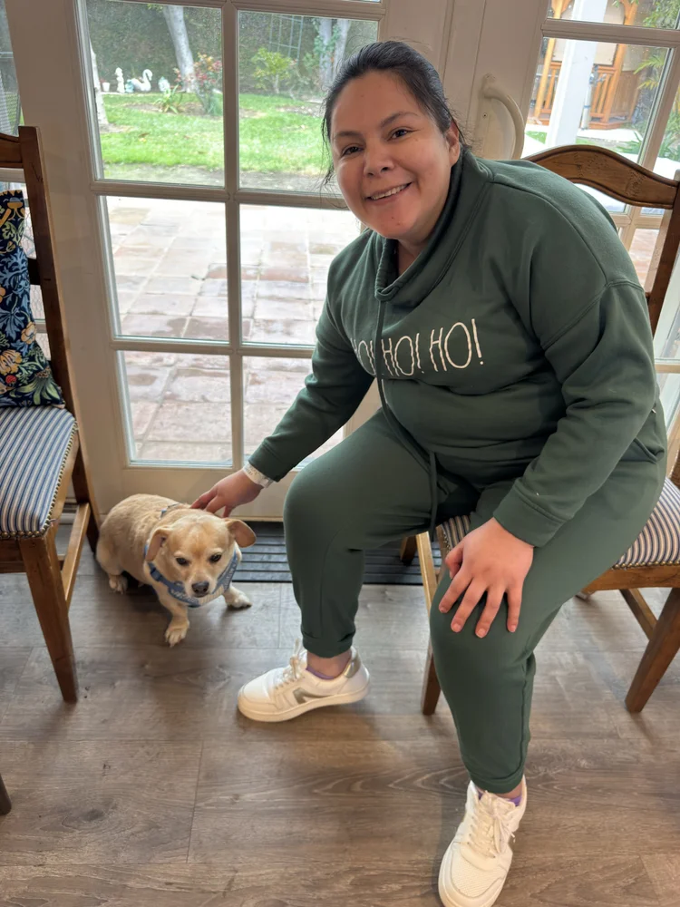Caregiver relaxing with therapy dog in comfortable home dining area