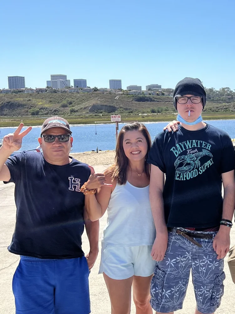 Three people enjoying a sunny day together at a waterfront location