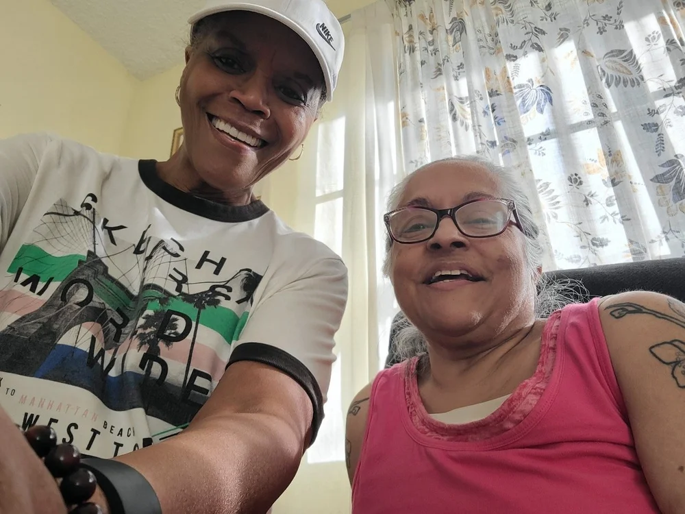 Caregiver and resident smiling together in a comfortable home setting